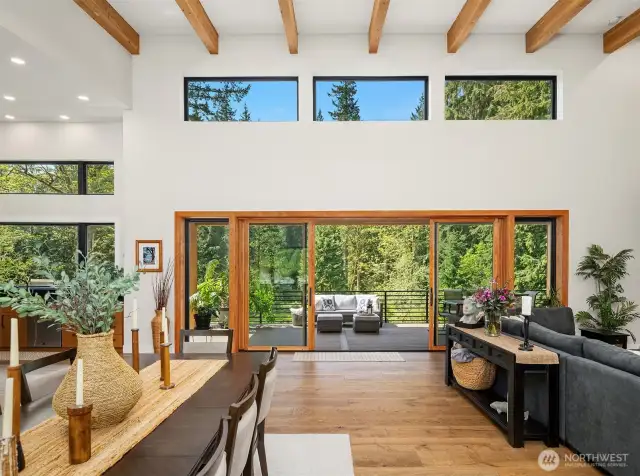 Open-concept great room with clerestory windows and large custom-built slider leading to the outdoor deck, overlooking the tranquil and secluded setting.
