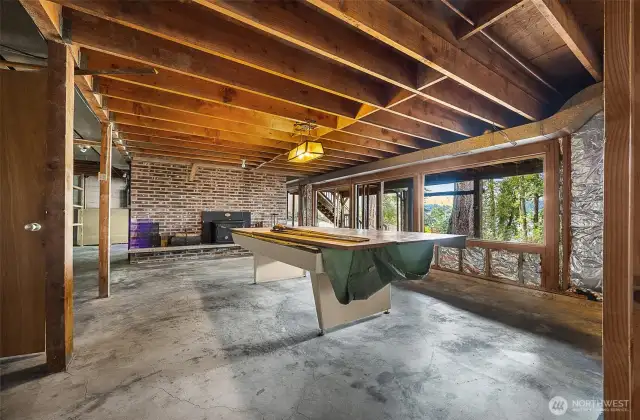 Unfinished space in basement used for the pool table.