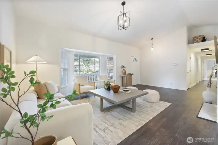 Vaulted ceiling and bay windows elevate the spacious feel of this light and bright living room.