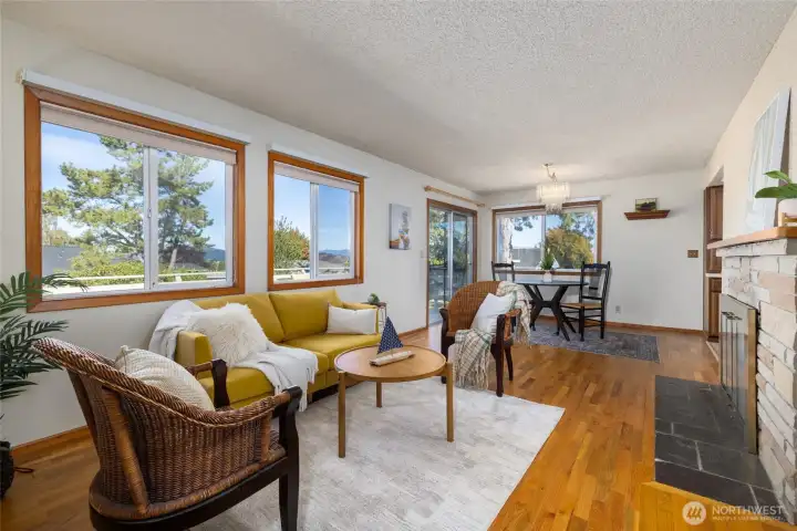 The main living area has large windows that look over the pack yard and partial water and mountain views. The cozy fireplace and original hardwood floors are an extra bonus in this home!