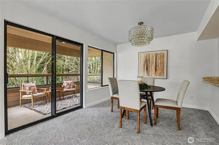 Dining area is subtly separated from the kitchen, with sliding glass doors that open up to a private balcony, offering serene park views.