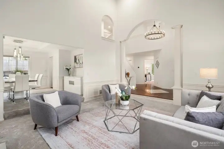 The open, airy layout flows beautifully between living spaces, with refinished hardwood floors, soaring ceilings, and an elegant chandelier adding a touch of timeless sophistication.
