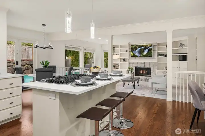 This stunning kitchen showcases crisp white cabinetry, pendant lighting over the island, and a seamless open sightline to the family room and backyard, the true heart of this exceptional home.