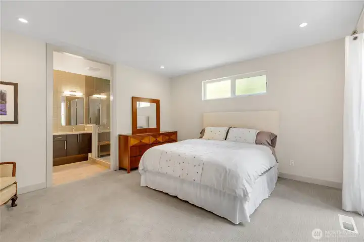 A sumptuous primary bedroom on the main floor with a seating area, spa-like bathroom, walk-in closet and sliders to the private patio and fully fenced yard.