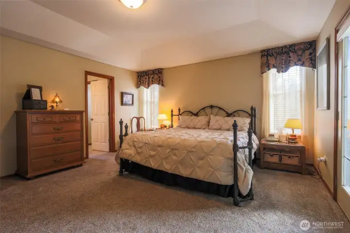 Large Primary Bedroom with tray ceiling. French doors open to spacious, private, covered back deck.