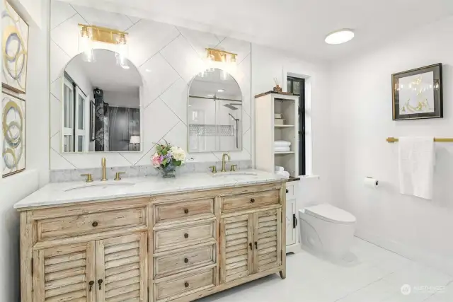 Remodeled primary bathroom with dual vanities and large walk-in shower.