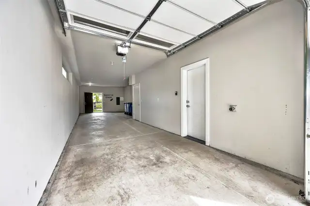 Huge 2 car tandem garage equiped with EV charging station, access to back patio and an extra walk-in storage room.