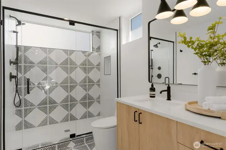 Designer ensuite bath with patterned tile detail.