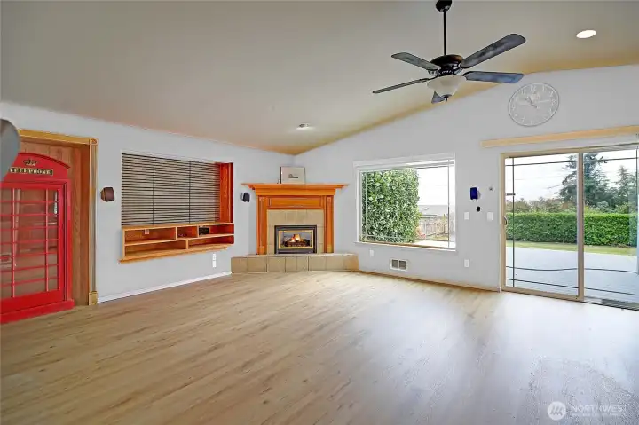 Spacious living room with cozy fireplace, vaulted ceilings, & large windows to enjoy the view!