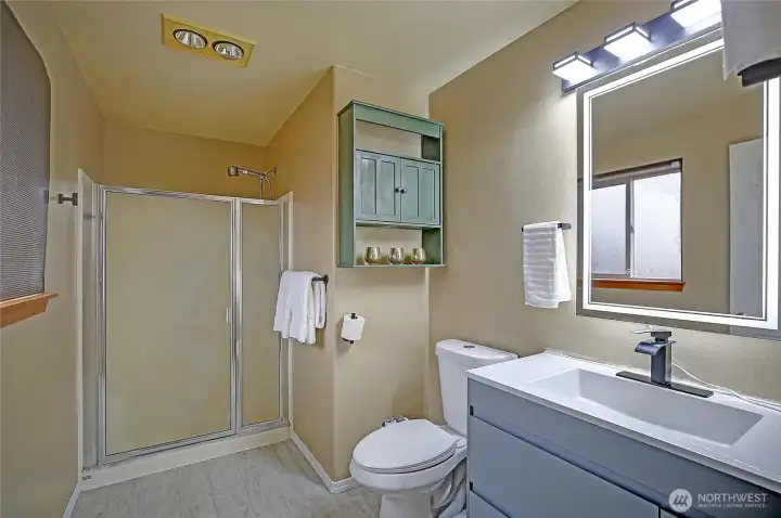 Cute updated primary bath features new sink & cabinet, mirror, light fixture & toilet!