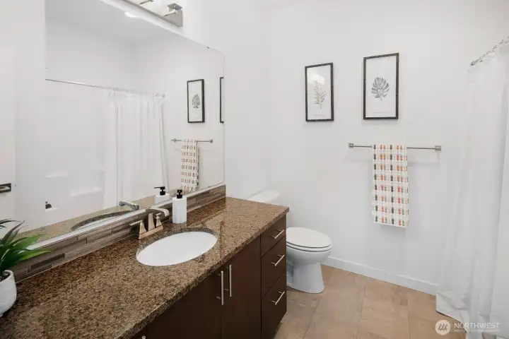 Second full bathroom with large mirror and vanity.