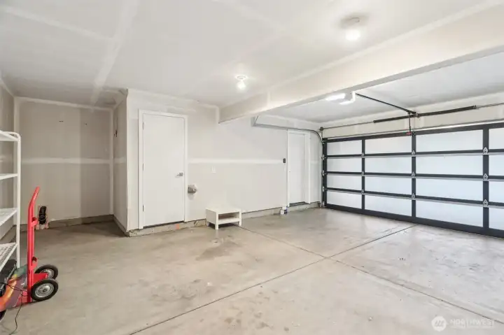 Spacious 2 car garage with additional storage closet and storage nooks