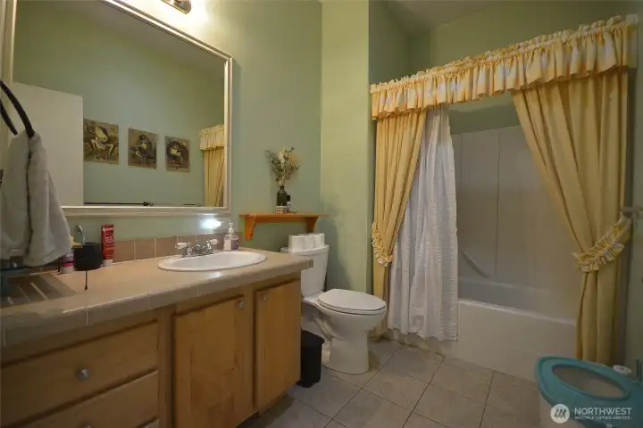 Primary bathroom showcasing the dual sink, toilet, and soaking tub.