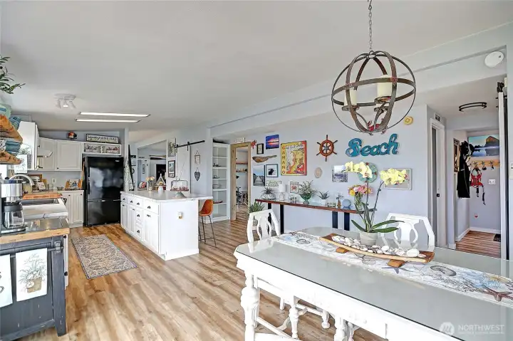 “Open dining area with stylish barn door pantry, utility room, and a functional layout connecting to two bedrooms and a full bath.