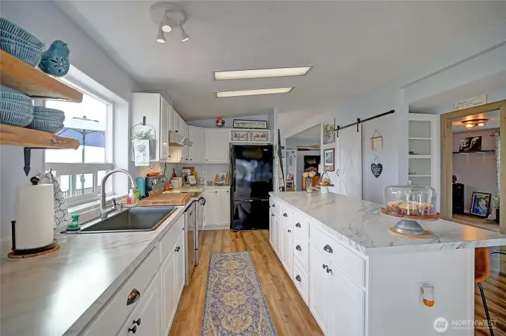 Light-filled kitchen featuring generous cabinetry, spacious countertops, and a functional layout.