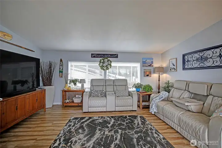 Spacious living room with large windows, abundant natural light, and comfortable layout.