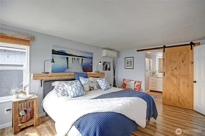 Spacious primary bedroom featuring mini-split heating and cooling with easy access to the ensuite bath.