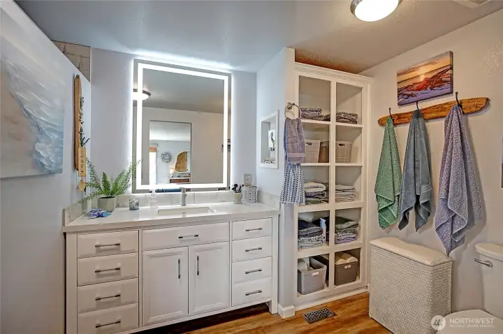 Updated en suite bathroom featuring a large vanity, ample storage, and a beautifully finished shower.