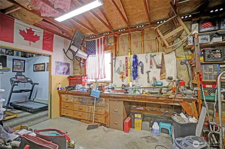 Versatile shop/garage featuring built-in storage, workbench space, and a separate area for a home gym.