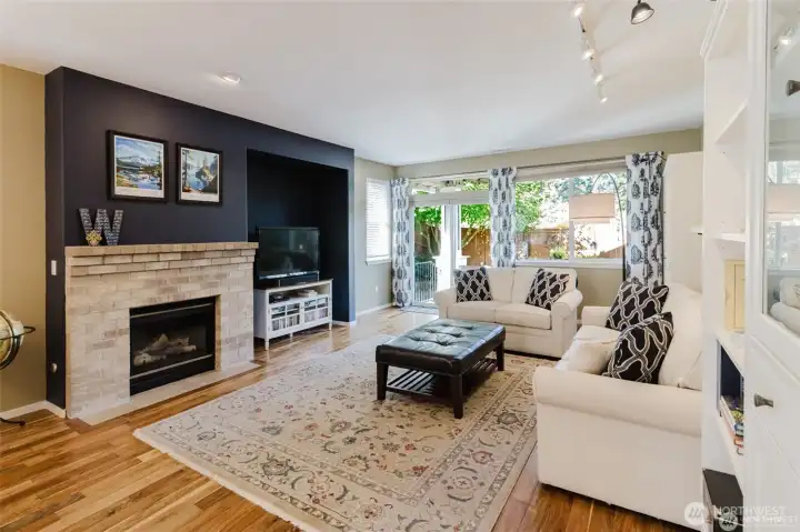 Spacious living room is topped off with a gas fireplace and lots of windows