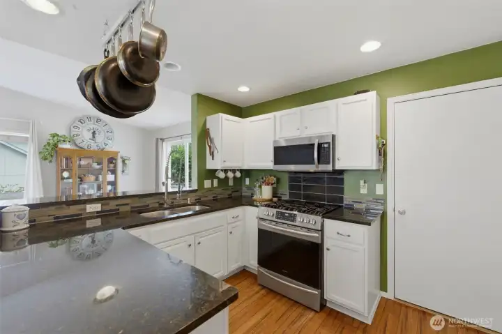 Crisp white cabinets and granite counters for a kitchen at the center of life