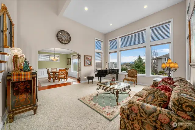 Formal living room with vaulted ceilings and oversized windows.