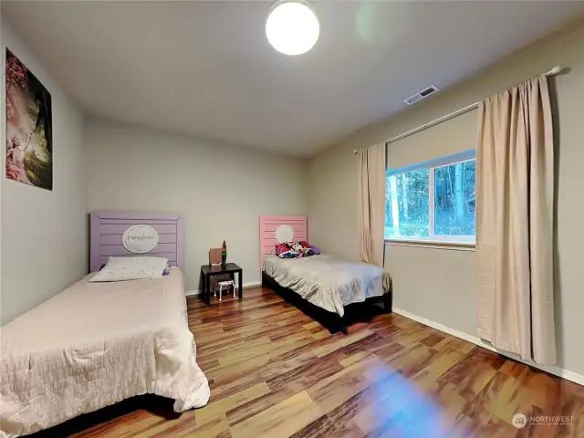 2nd bedroom still boasts the laminant hardwood, offering plenty of room for two beds, with window out to backyard