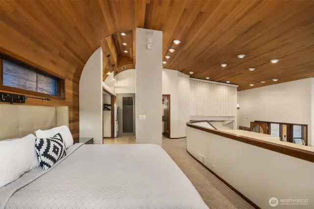 The marine reference is particularly present in the primary bedroom with its curved ceiling lines and warm wood finishes.