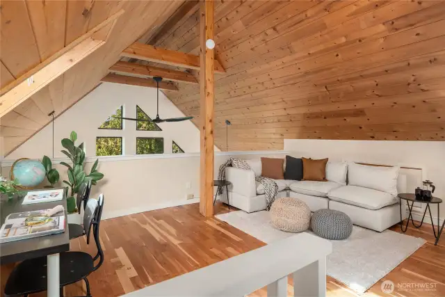This spacious lounge area is lofted above the main living room and enjoys views through the main window wall.