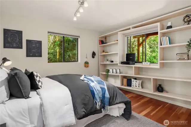 The third bedroom located on the main floor features a custom built, off-kilter (deliberate) shelving unit built by a local artisan. An impressive work of art!