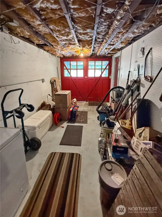 A rare find in homes of this era — this original garage bay offers direct outdoor access and loads of extra storage or workshop space. The bold red carriage doors make a statement, while the pegboard wall and open rafters add to the vintage utility-shop vibe. Whether you’re storing gear, tuning bikes, or dreaming up your next project, this space is ready to work as hard as you do.