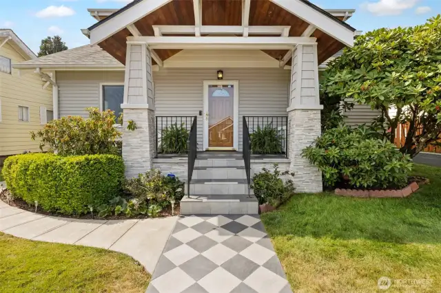 Beautiful front porch with custom checkerboard walk, stonework, and a nicely finished ceiling to welcome you and your guests.