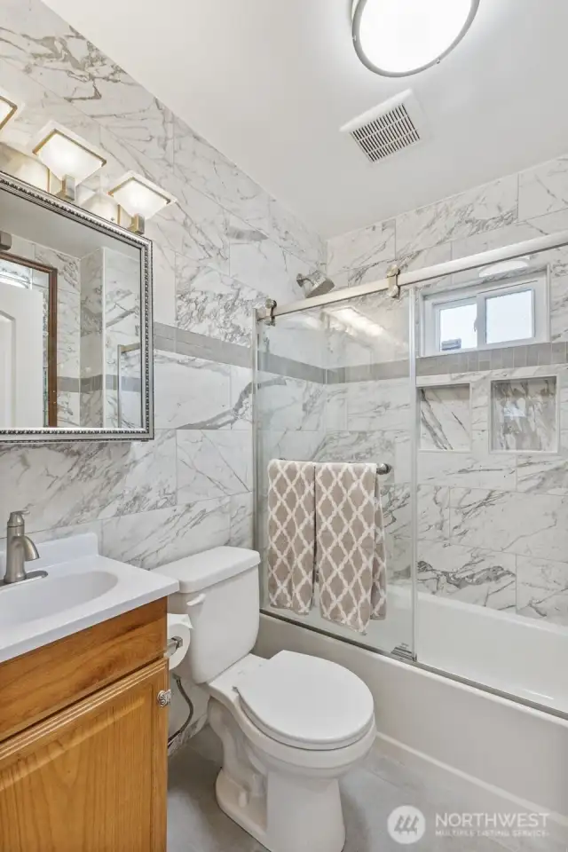 Downstairs full bath has been pleasantly updated with gorgeous tile.