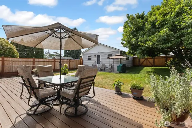 Another view of the large deck. The backyard is fully fenced with newer fencing. Sit and relax or invite guests over for a BBQ dinner. The grill & gazebo in the background can stay. Patio furniture to go with sellers.