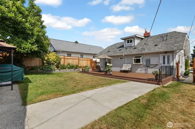 A backyard view back toward the house showing the great low profile deck. Access via the back alley gate for fewer stairs. Gate access to the front yard at the right of photo.