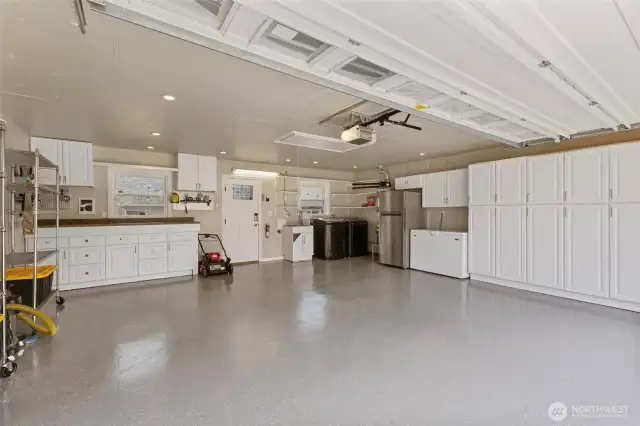 Additional cabinets and workbench area with door to backyard. 2nd laundry hook up in garage with utility sink and 2nd water heater (behind fridge). Washer/dryer and box freezer can stay. Refrigerator to go with sellers.