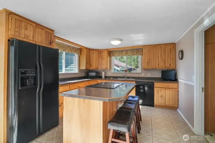 Kitchen with island, wood cabinets, laundry room to the right