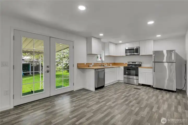 Kitchen with French doors that lead out to Back yard with cover awning.