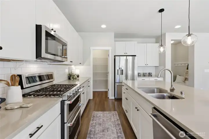 Note the gas range and double oven, thoughtfully designed to elevate everyday cooking. Note the gas range and double oven, thoughtfully designed to elevate everyday cooking.