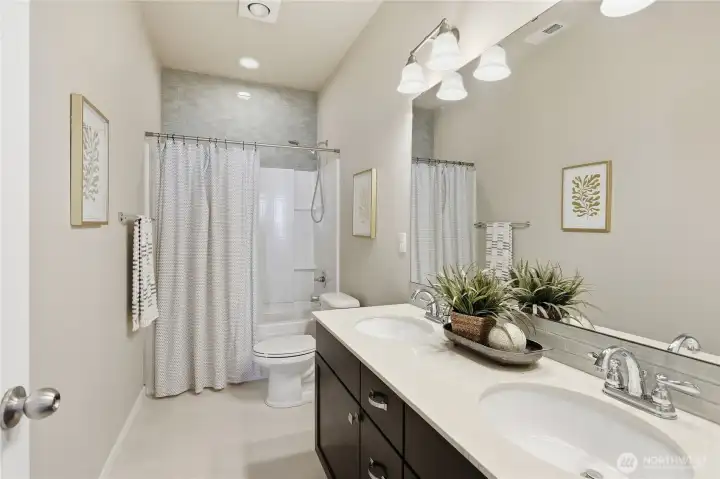 The upstairs full hall bathroom features beautiful designer tile and dual sinks, offering both style and convenience for busy households. The upstairs full hall bathroom features beautiful designer tile and dual sinks, offering both style and convenience for busy households.