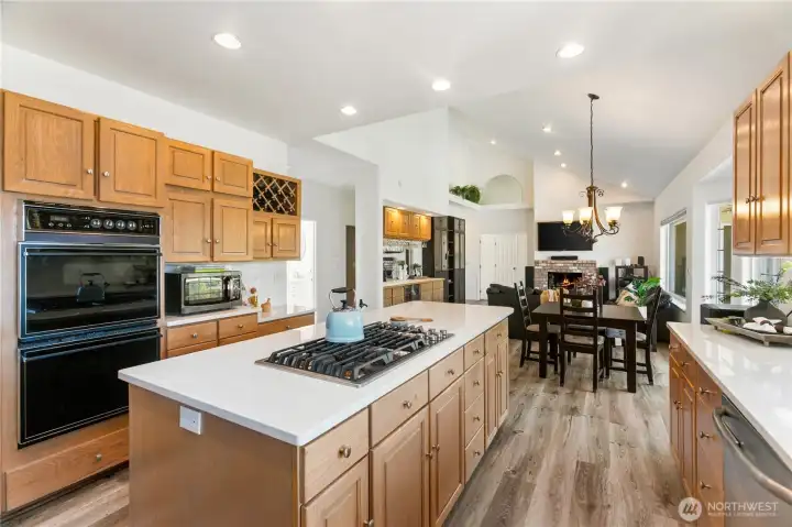 Looking towards the family room and additional dining brand new cook top, double ovens, fireplace in the family room and great bar or china display with under counter refrigerator.