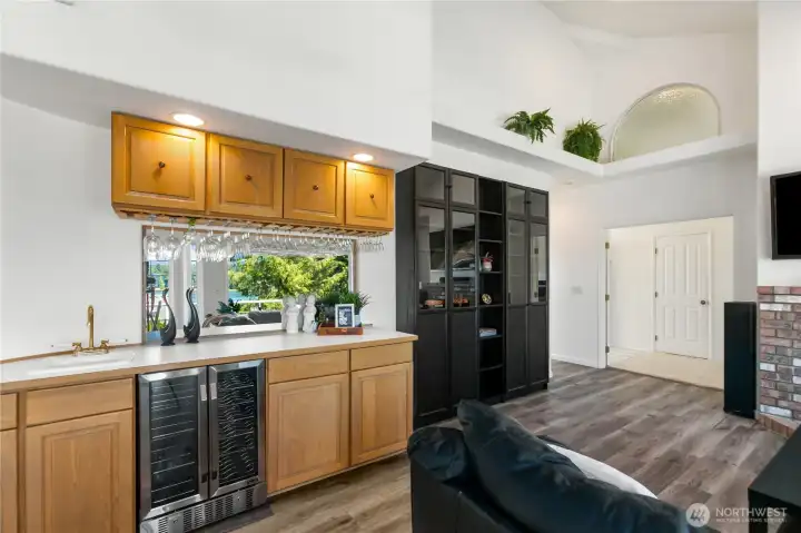 Wet bar with oversized under counter refrigerator.  Glass display with sink and lots of cabinets.  Double doors on right lead to the master bedroom