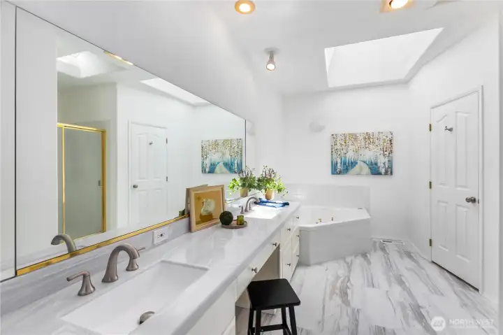 Primary Bath with jetted tub, double sink, full shower, toilet & Bidet, skylight.  New counter tops and vinyl plank flooring.