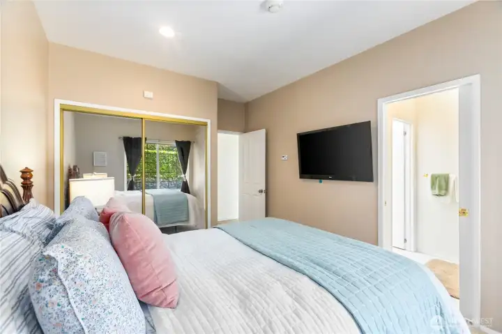 View of the guest bedroom into the shower area of the main bathroom that has separate door to close off the shower from the toilet and sink.