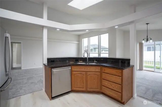 The kitchen offers a view into the open living area, showcasing the home's bright and airy atmosphere.