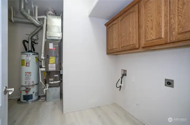 The utility room offers extra overhead cabinets, providing plenty of additional storage space.