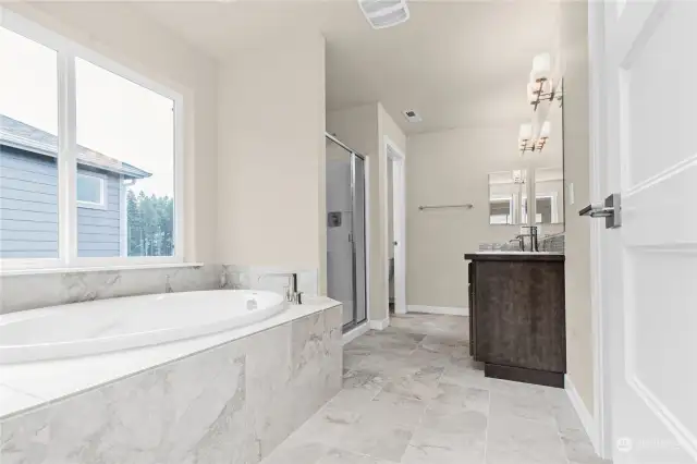 Similar home, not actual. Primary bathroom with tile flooring.