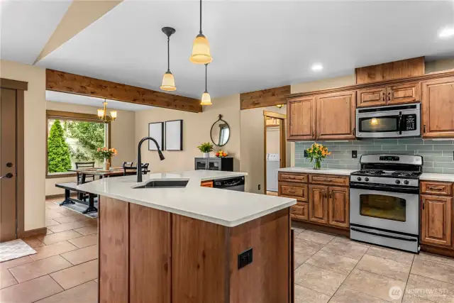 Modern kitchen with center island, dual sink, and stainless appliances.