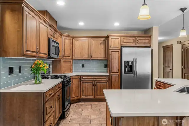 Kitchen with expansive island, dual sink, and open view to living room.