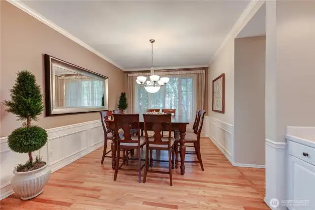 Formal dining room with crown molding, wainscoting and a butlers pantry.